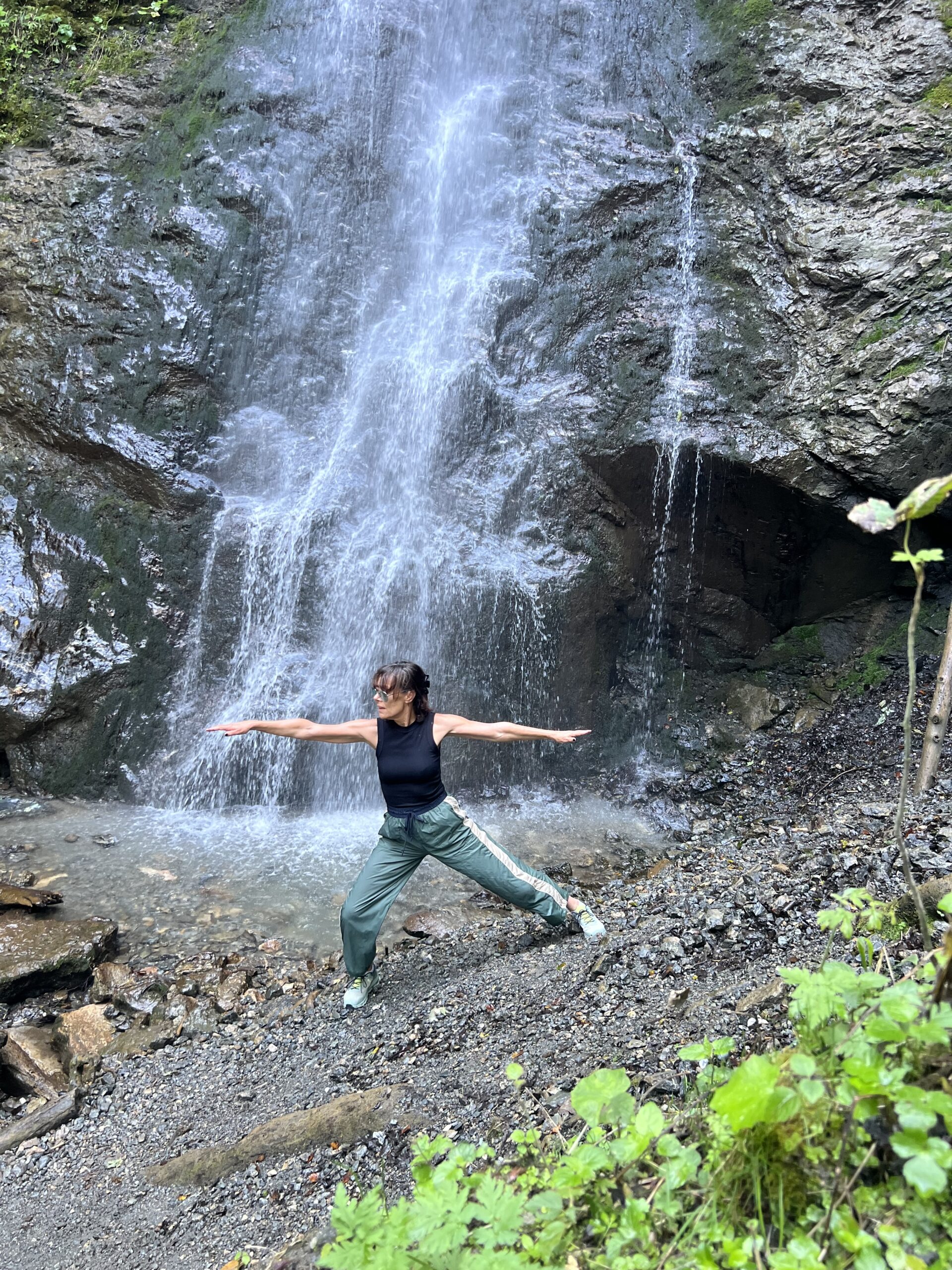 Dominique practising Qigong outdoors by a waterfall